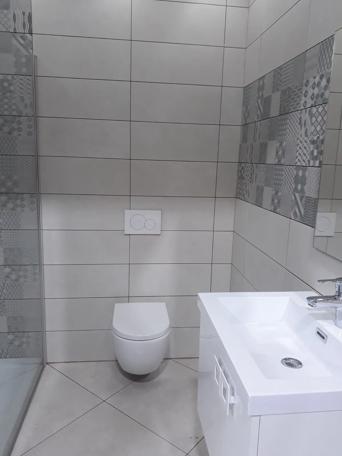 Gerenoveerde badkamer met hangtoilet, inloopdouche en decortegels – IDGS Constructions, regio Schilde
