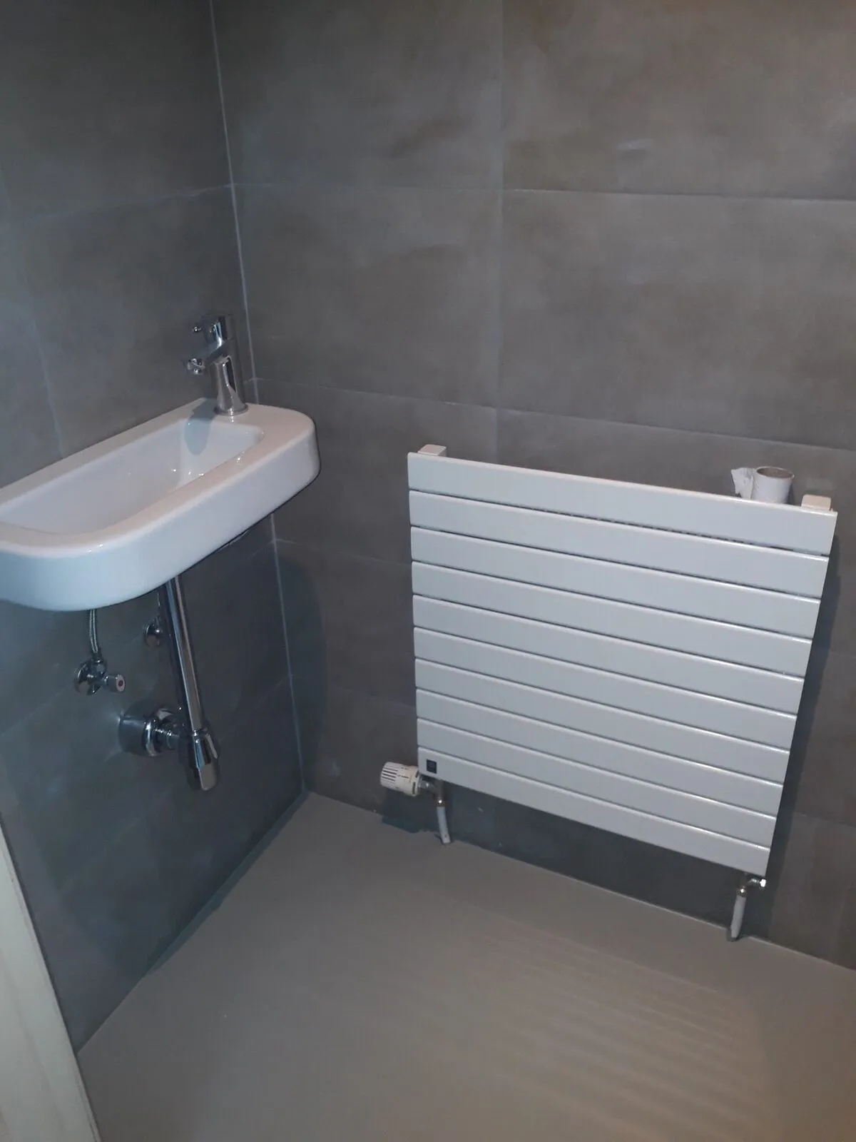 Toiletruimte met fonteintje, designradiator en antraciet tegels – IDGS Constructions, regio Zaventem