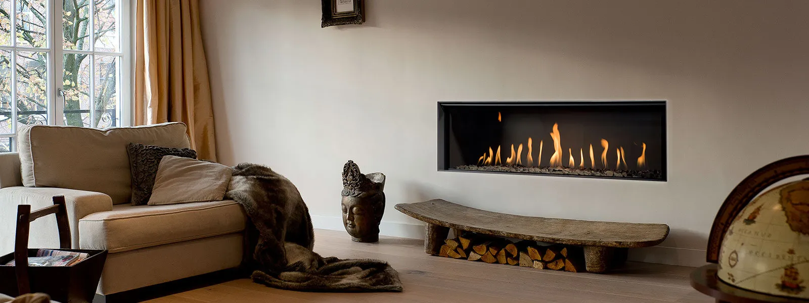 Lange inbouwhaard boven een houtblok in een living