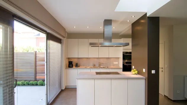 Witte designkeuken met kookeiland en dampkap