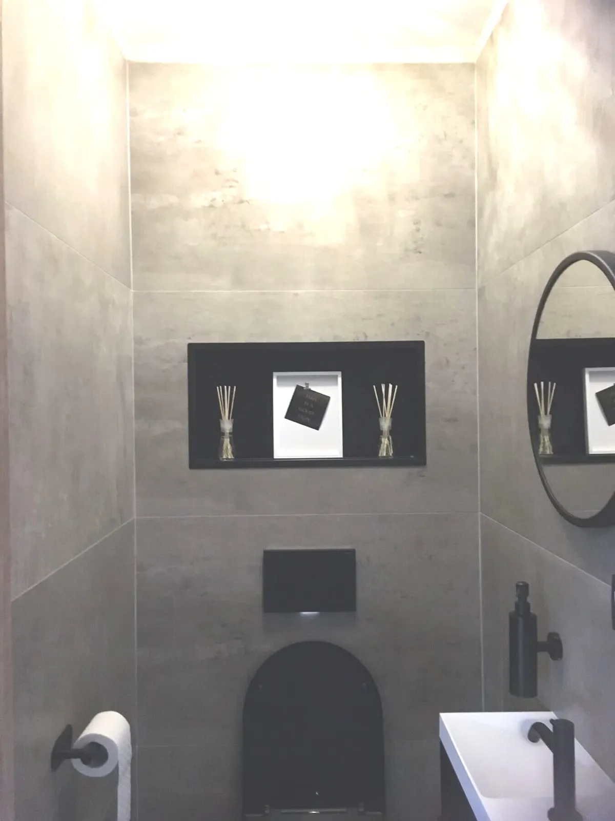 Gerenoveerd toilet met betonlooktegels, hangtoilet en nis in Antwerpen