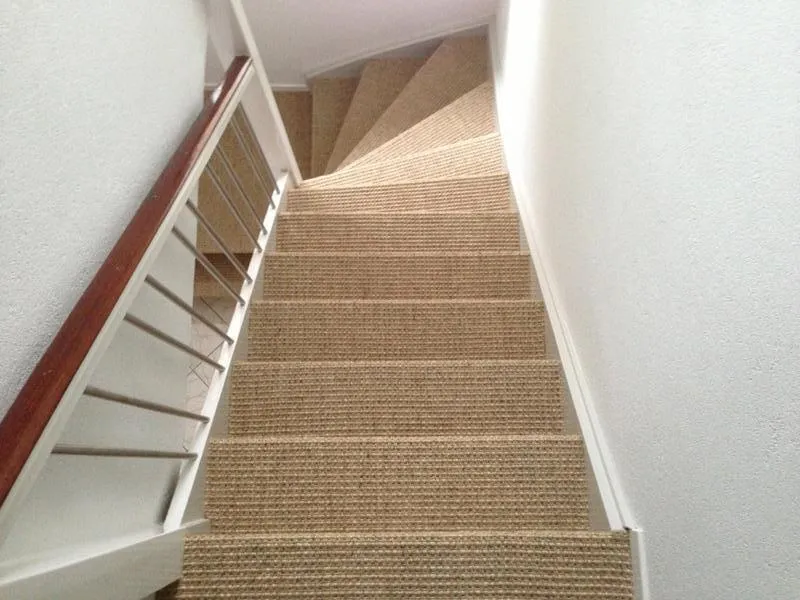 Gerenoveerde trap met sisal traploper en witte leuning in Antwerpen