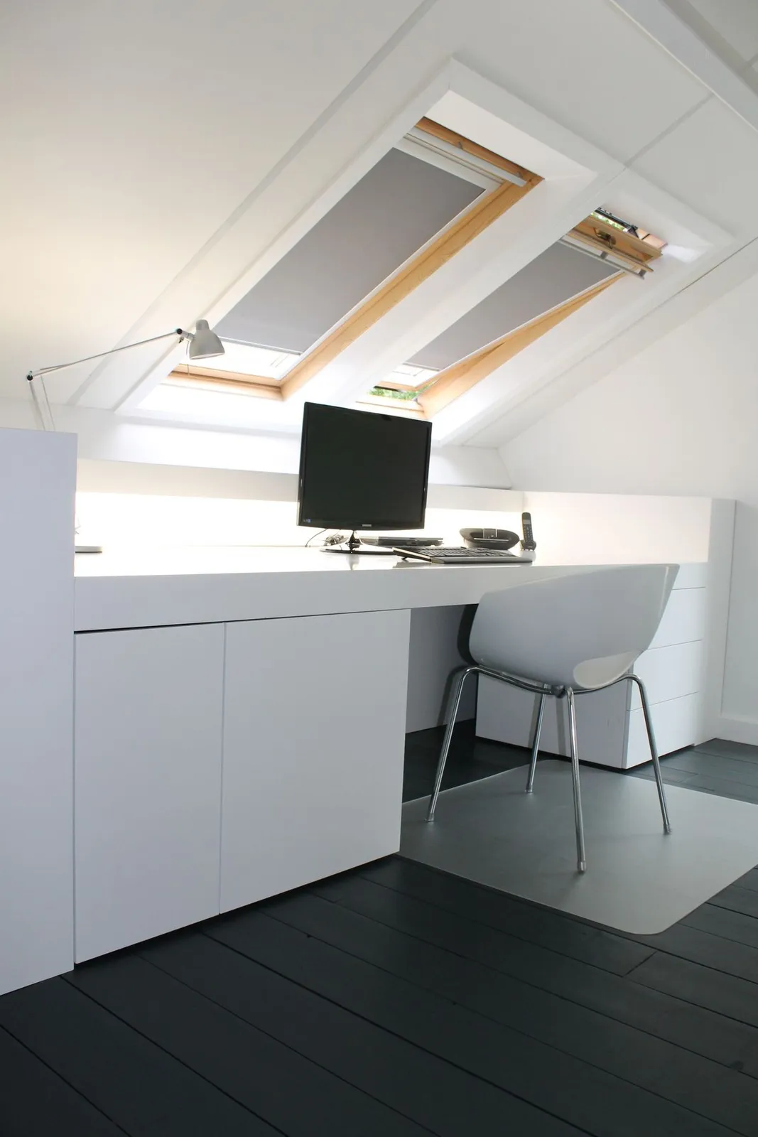 Zolder omgebouwd tot bureau met dakraam en maatwerkkasten na de renovatie in Antwerpen