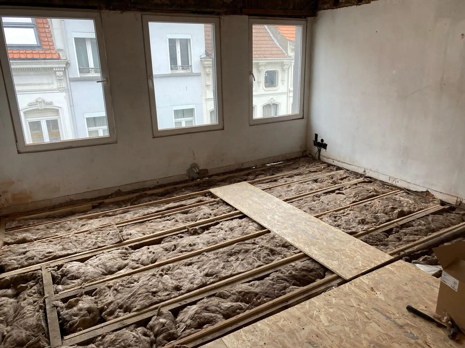 Zoldervloer met isolatie tussen de balken vóór de renovatie in Antwerpen