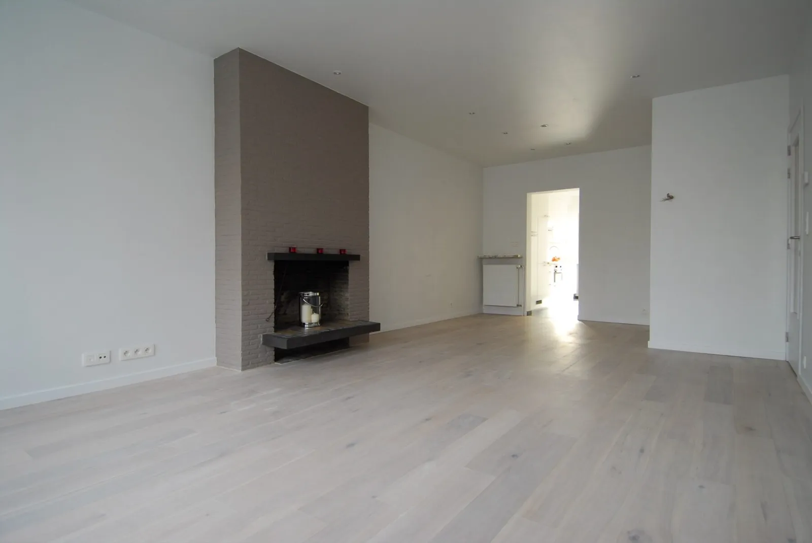 Lichte living met parketvloer en haard na de renovatie – IDGS Constructions, regio Mechelen