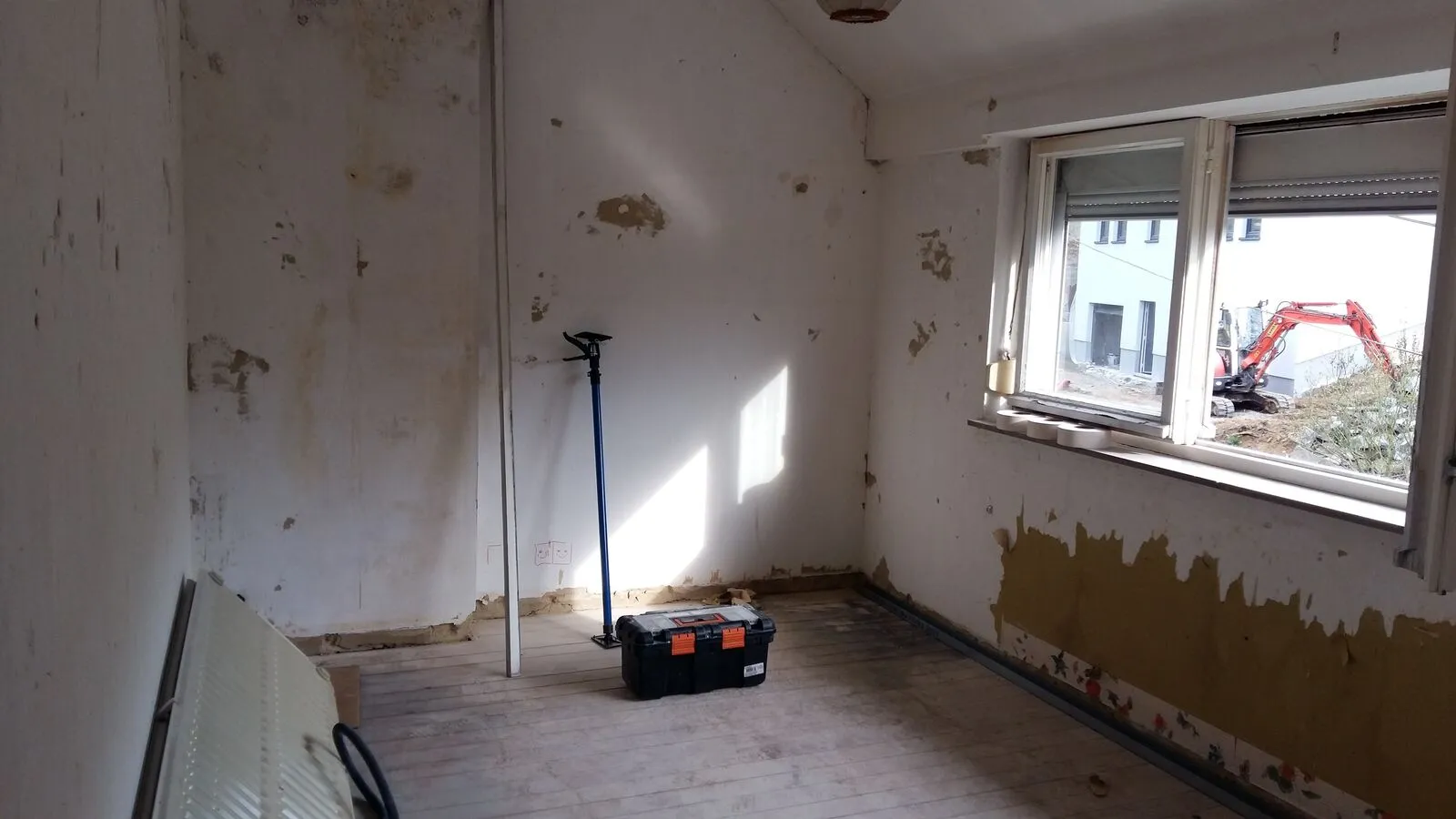Leeggemaakte keuken met beschadigde muren vóór de renovatie in Rixensart